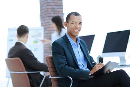 portrait of a successful businessman sitting at desktop in office.