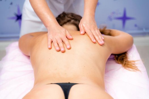 Facial massage. A woman is given a massage in a beauty salon. Close-up