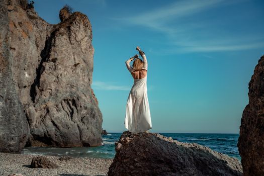 Middle aged woman looks good with blond hair, boho style in white long dress on the beach decorations on her neck and arms