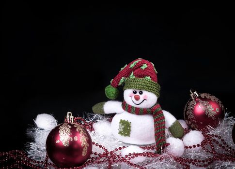 fun toy snowman and Christmas decorations on a black background.photo with copy space