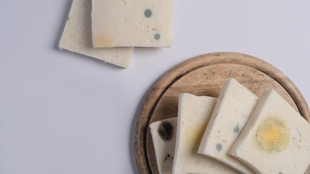 Moldy sliced bread, expired bread on white background.