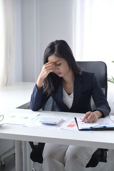 Frustrated businesswoman sitting at her office desk.