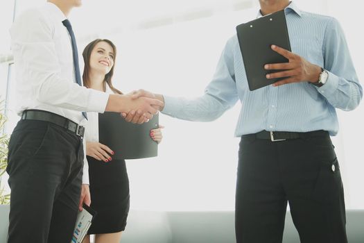 handshake of business partners standing in the office.the business concept
