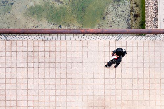 top view of a young urban man walking with a backpack, concept of urban lifestyle