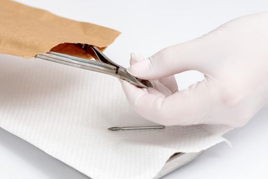 Close-up of manicurist hand is taking manicure tool from craft envelope in manicure salon.