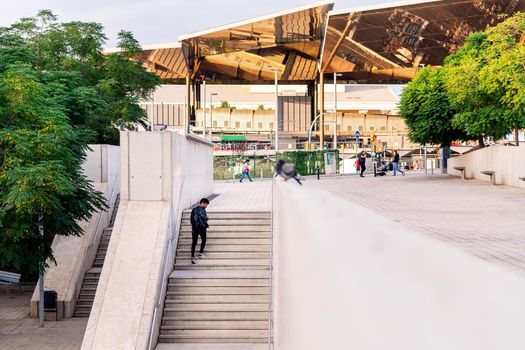 stylish young latin student with backpack climbing stairs in the city, concept of urban lifestyle