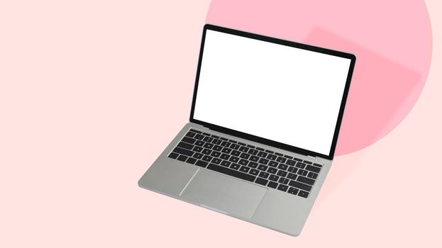 Computer laptop isolated on pink pastel background. Blank display for graphic display montage.