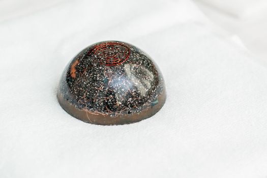 Close up of hot black massage stone sitting on white towel in spa.