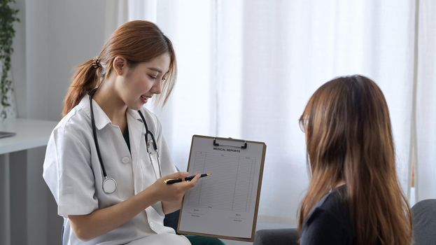 Female doctor in white medical uniform giving advice to a female patient.