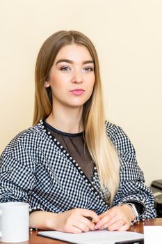 Portrait of a casual business woman sitting at her workplace in home office.