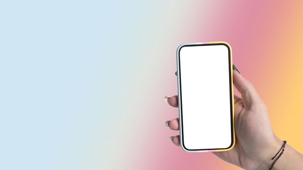 Woman hand holding smart phone isolated on gradient colorful pastel background. Empty display for graphic display montage.