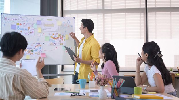 Asian male business team leader giving presentation start up business strategy in meeting.