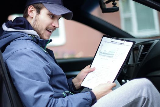 closeup.man with documents sitting in the car