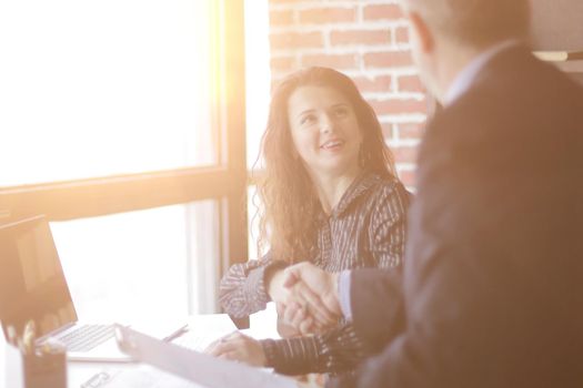 handshake Manager and client sitting at your Desk in the office.