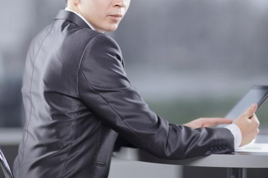 businessman with digital tablet sitting in a cafe near a large window.