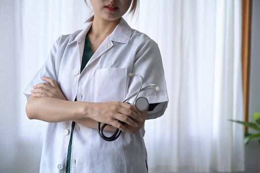 Female doctor in white uniform holding stethoscope in hand. Healthcare and medical concept.