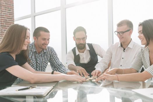 top view. business colleagues collecting puzzle, sitting at the table. business concept