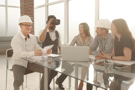 professional designers discussing ideas about blueprint during meeting table in modern studio