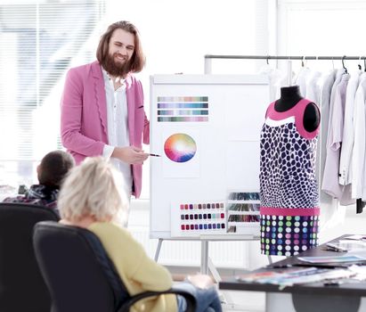 fashion designer showing colleagues the color palette for the new collection.