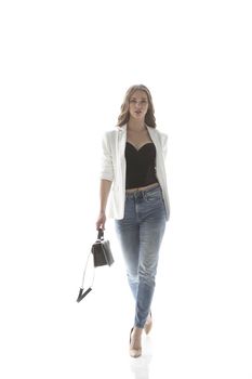 confident young woman with a graceful bag goes forward .isolated on white.photo with copy space.