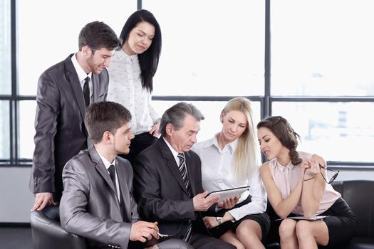 businessman uses a digital tablet at a working meeting with employees . business and technology
