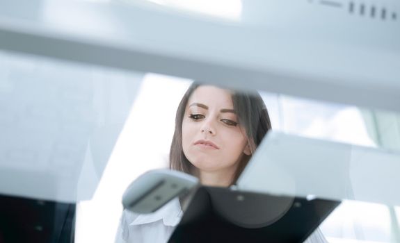 bottom view.young business woman reading a working paper.business concept