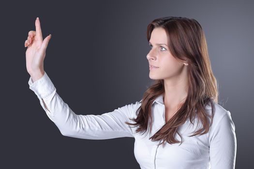 modern successful business woman presses on a virtual button.isolated in the dark.photo with place for text