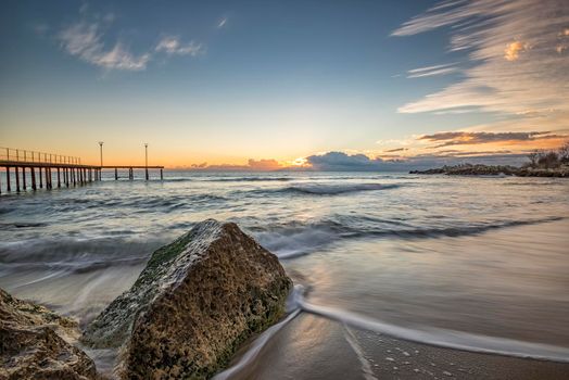 Sea wave motion blur, low angle view, a beautiful view with first rays over the sea