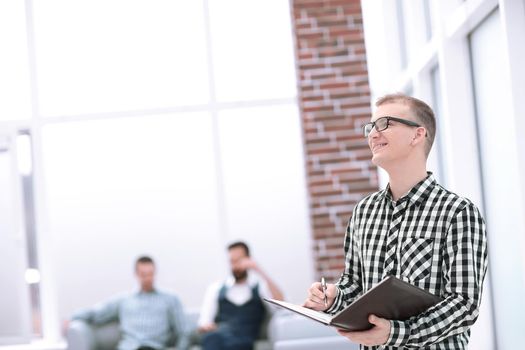 employee with a clipboard standing in the office .photo with copy space