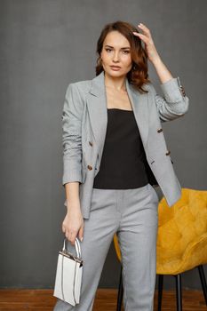 A girl in a business suit, on a studio background. Shooting clothes.
