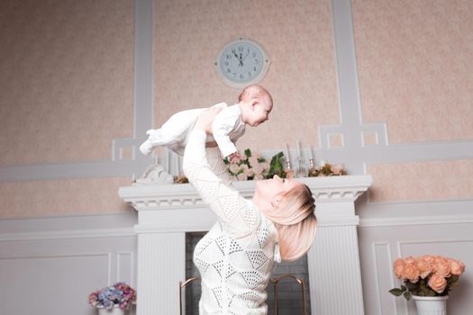 mom plays with the baby in the cozy living room. photo with copy space