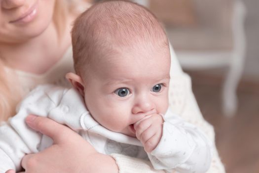 mother with baby sitting near the fireplace in a cozy living room. photo with copy space