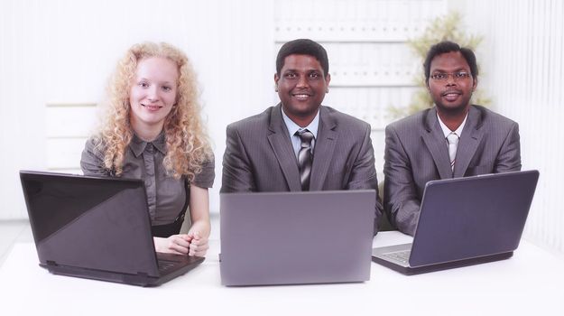 employees sitting in front of open laptops. isolated on white background