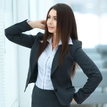 Executive business woman standing near window in spacious office.photo with copy space