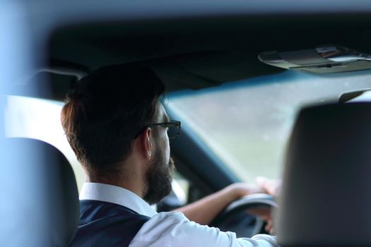 rear view.business man sitting in a modern car.transport and people