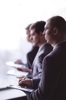 image of a businessman being at the conference and making notes on the foreground.