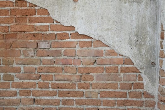 Empty old brick wall with peeling plaster, grunge background. Copy space for your text.