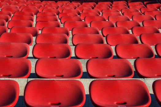 Empty plastic red chairs In outdoor theater  in sunny day. Close Up.