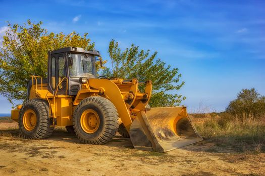 day view of yellow excavator with shovel after work