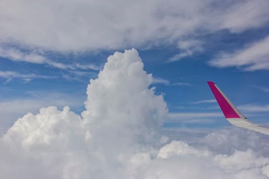 View from airplane.  The wing of an airplane and amazing white clouds at blue sky
