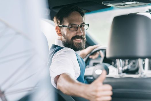 rear view.business man sitting behind the wheel of a car.transport and people