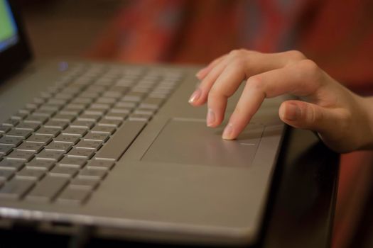 Woman working at home office hand on keyboard close up. Side view