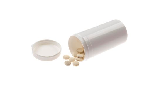 pills spilled from pills bottle. Pills and medicine container lying on white background.