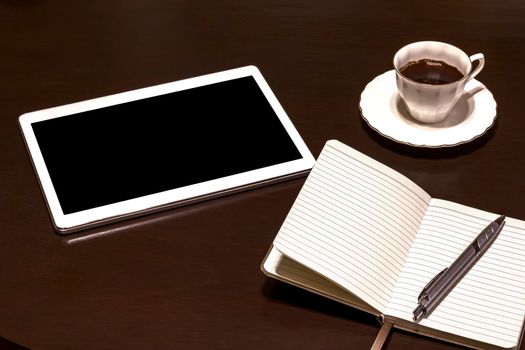 Work table: tablet PC, glasses, notebook, pencil and coffee. Gadgets on a wooden table.