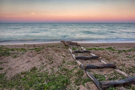 Stairway to sea. Dry wooden boat dock in the sand 