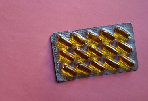 Full tablet of medicine in orange capsules
