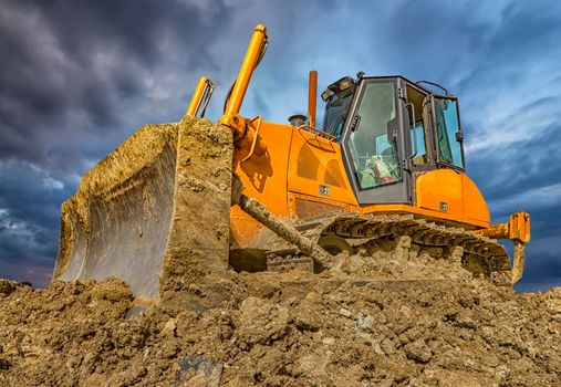Amazing colorful view of stopped bulldozer and blade into the ground. Wide angle, close up