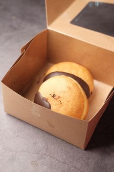 chocolate donuts in a paper packet on table .