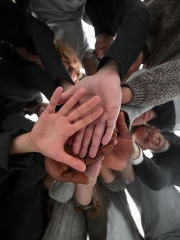 bottom view. group of happy young people making a tower out of their hands . concept of unity