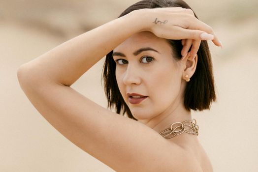 girl in a black long dress in a sandy desert under a blue sky